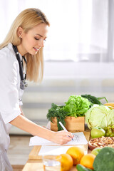 Wall Mural - Nutritionist writing healthy diet plan for patient with healthy fruit and vegetable on table, Right nutrition concept