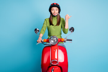 Poster - Photo of astonished person driving moped direct thumb empty space offer isolated on blue color background