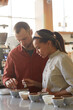 © Seventyfour - Vertical side view portrait of two people assesssing coffee quality diring cupping test in cafe