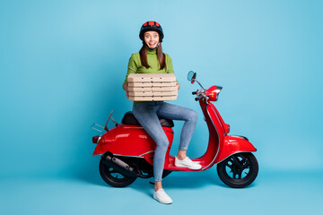 Poster - Full length photo portrait of excited woman holding pizza boxes sitting on red scooter isolated on pastel blue colored background