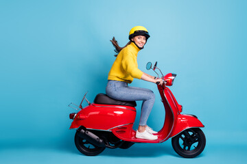 Wall Mural - full length photo portrait of cute girl driving red scooter isolated on pastel blue colored backgrou