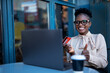 © JustLife - African businesswoman in cafe makes a purchase on the Internet. Beautiiful woman on the laptop with credit card..
