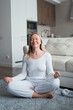 © shapovalphoto - woman in yoga meditation pose at home, me time and wellness concept