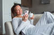 © shapovalphoto - woman drinking coffee and using mobile phone, video chatting or texting with friend
