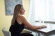 © shapovalphoto - woman sitting at table at home with wine glass