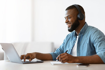 Wall Mural - Online Education. Happy Black Guy Study In Internet, Watching Webinar On Laptop