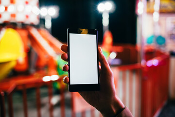 Smartphone with blank screen in woman's hand against background of city street