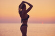 © Kalim - Silhouette of sexy woman posing at sunrise at the beach