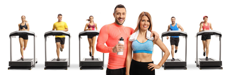 Poster - Young man and woman in sportswear with people running on treadmills in the back