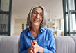 © insta_photos - Happy middle 60s aged woman teacher, psychologist laughing talking to webcam of grey haired elderly business woman staying in living room at home on virtual meeting, web cam view video call.