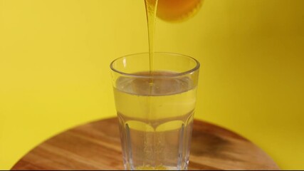 Poster - A person adding a syrup in a glass of sparkling water on a wooden board