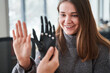 Woman comparing her hand with bionic prosthesis limb while sitting