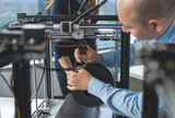Fototapeta  - An engineer adjusts the 3D printer to get started manifacturing.3D printing industry_