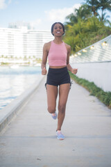 portrait of a young African American woman jogging out doors by the water