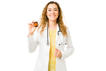 Wall Mural - Happy professional doctor showing a bottle of medicine