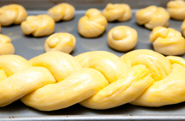 Closeup of raw dough in the form of a braid on a sheet pan