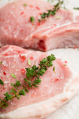 Wall Mural - Raw pork meat with thyme and spices on the rustic background. Selective focus. Shallow depth of field.