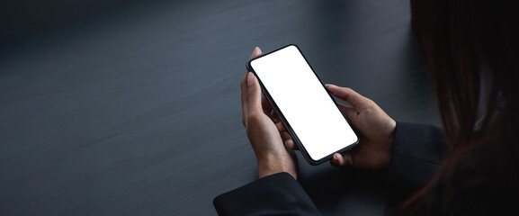 cell phone blank white screen mockup. woman hand holding texting using mobile on desk at office.background empty space for advertise.