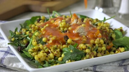 Poster - Pouring salad dressing on a chicken, arugula coucous salad
