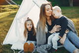 Fototapeta Londyn - Mother with children playing in a summer park