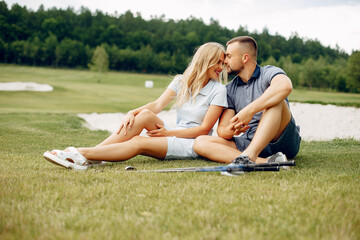 Wall Mural - Beautiful couple playing golf on a golf course