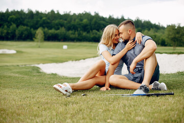 Wall Mural - Beautiful couple playing golf on a golf course