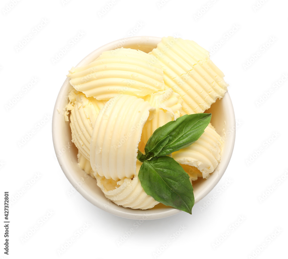 Bowl with fresh butter and basil on white background