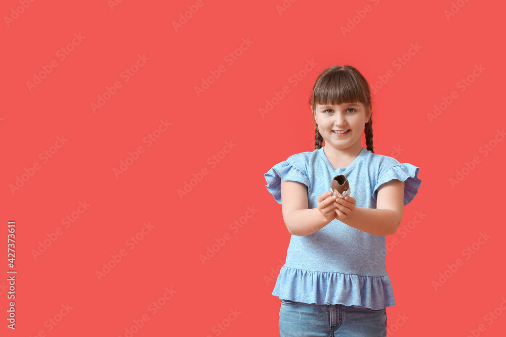 Cute little girl with chocolate Easter egg on color background