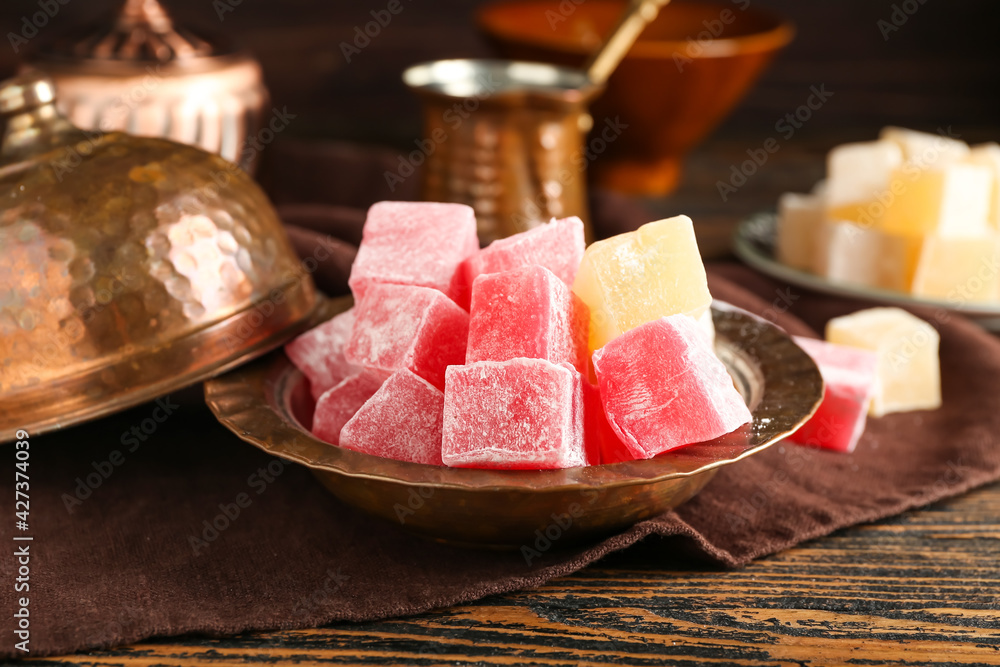 Plate with Turkish delight on wooden background