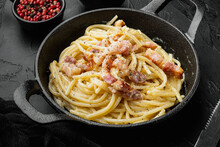 Traditional Italian Dish Spaghetti Carbonara With Bacon In A Cream Sauce, In Cast Iron Frying Pan, On Black Stone Background