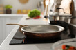 © New Africa - Frying pan on modern cooktop in kitchen