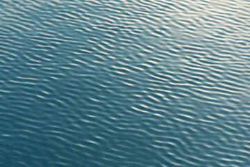 Small waves abstract or rippled water texture background, lake, sea or river with sunset or sunrise reflection 