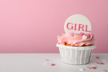 Baby Shower Cupcake With Girl Topper On White Table Against Pink Background, Space For Text