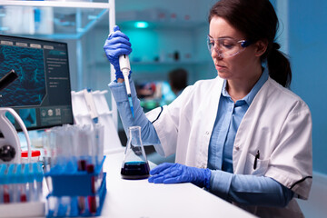 Scientist using micropipette to take sample to analyse it in medicine healthcare laboratory. Woman research a new experiment in modern lab, analyzing pharmaceutical work with modern equipment.