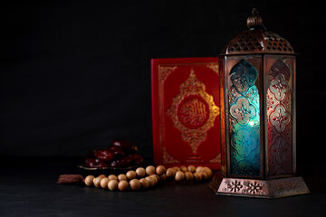 Composition with Arabic lantern and quran on black table. Space for text