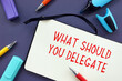 © Yurii Kibalnik - Financial concept meaning What Should You Delegate with inscription on the sheet.
