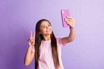 Sticker - Photo of charming cute schoolgirl dressed t-shirt tacking selfie modern device showing v-sign isolated purple color background