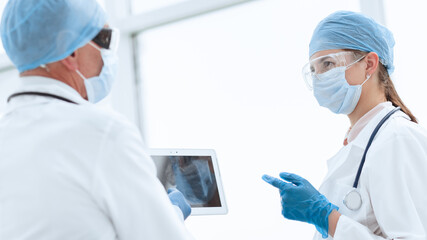 woman doctor looking at the screen of a digital tablet.