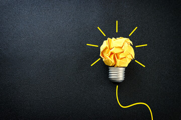 Wall Mural - Education concept image. Creative idea and innovation. Crumpled paper as light bulb metaphor over black background