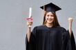 © EduLife Photos - A young happy Asian woman university graduate in graduation gown and mortarboard holds a degree certificate celebrates education achievement in the university campus.  Education stock photo