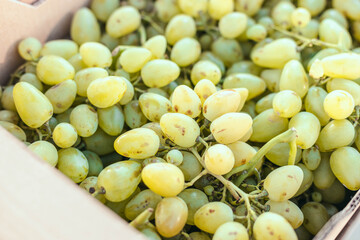 Fresh fruit brunch green grapes in paper boxes at the local market