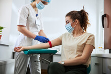 Experienced Phlebotomist Preparing A Woman For Blood Draw