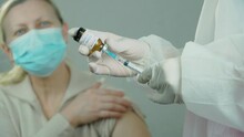 Medical Vaccination Equipment With Syringe With Needle And Ampoule In Doctor Or Nurse Hand On Background Of Female Patient In Hospital. Medicines Research Concept And Defeating Dangerous Covid-19