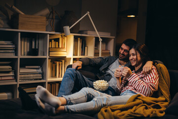 young couple watching television together at home