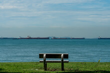 One Empty Bench Against Tropical Sea And Vessels