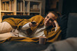 © cherryandbees - woman watching television relaxed on sofa at her home