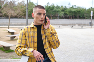 Wall Mural - Young non binary person talking by his smartphone. Make up androgynous person.