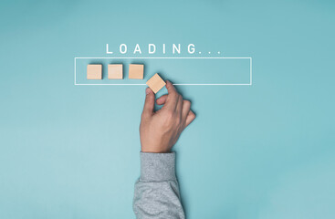 hand putting wooden cube block with infographic for download on blue background , technology and bus