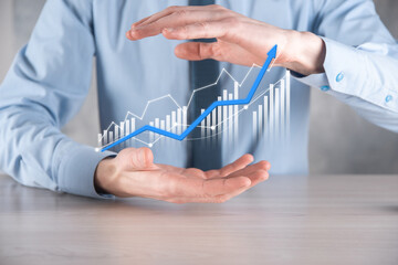 Businessman man holding a graph with positive profits growth. plan graph growth and increase of chart positive indicators in his business.more profitable and growing