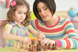 © aletia2011 - Beautiful young mother with her cute little daughter playing chess